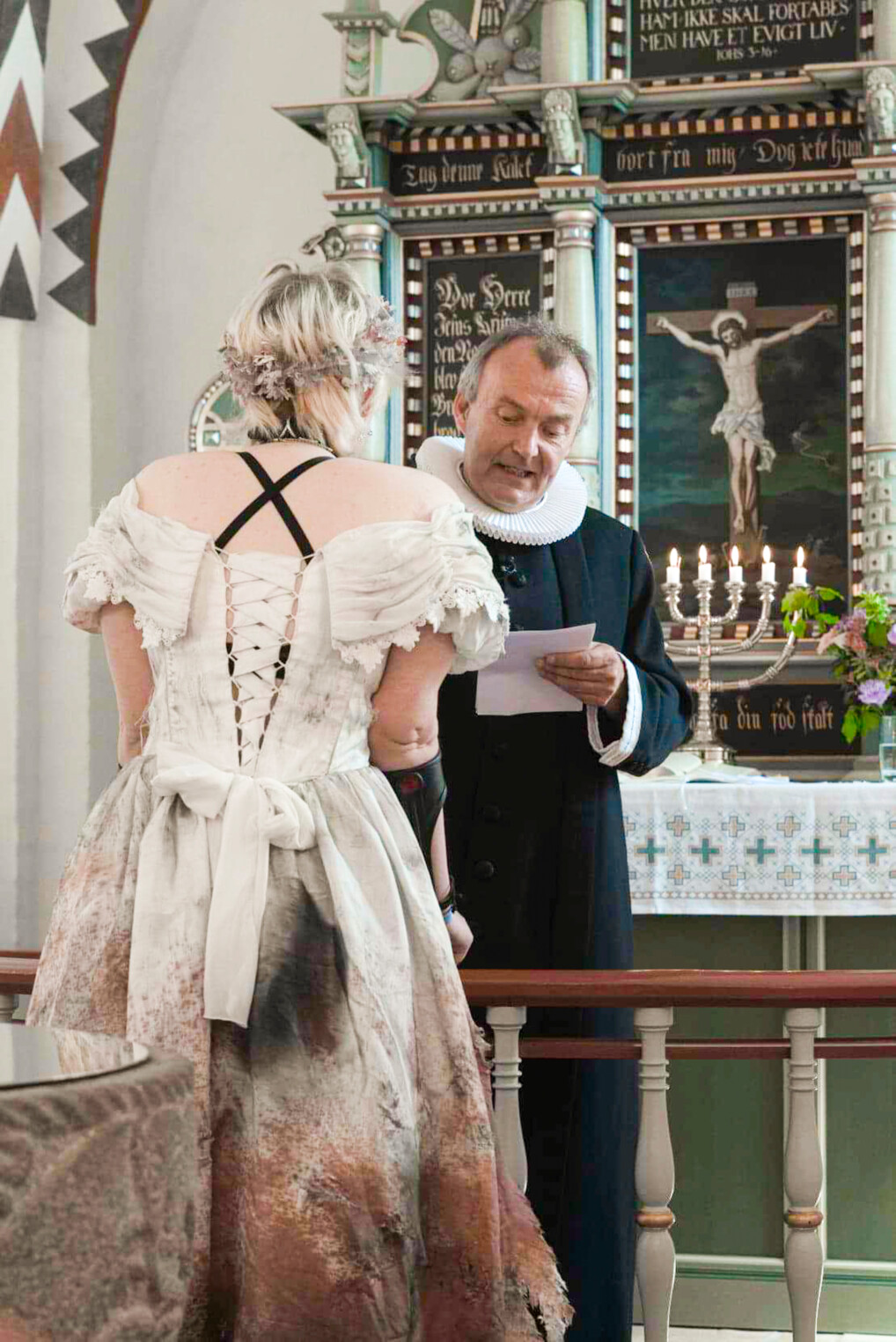 Rina bliver konfirmeret ved alteret i en gammel brudekjole, som hun har malet og rettet til.