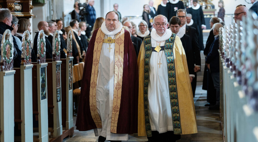 Biskop Thomas Reinholdt Rasmussen og biskop Peter Skov-Jakobsen går ned ad kirkegulv