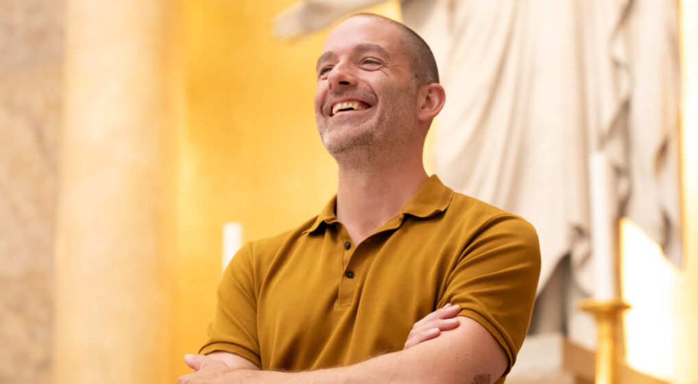 Portræt af grinende mand foran Jesus-statuen i Københavns domkirke