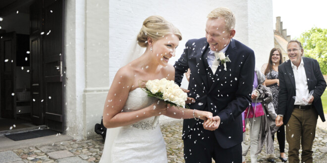 Brudepar får kastet ris efter sig uden foran en kirke