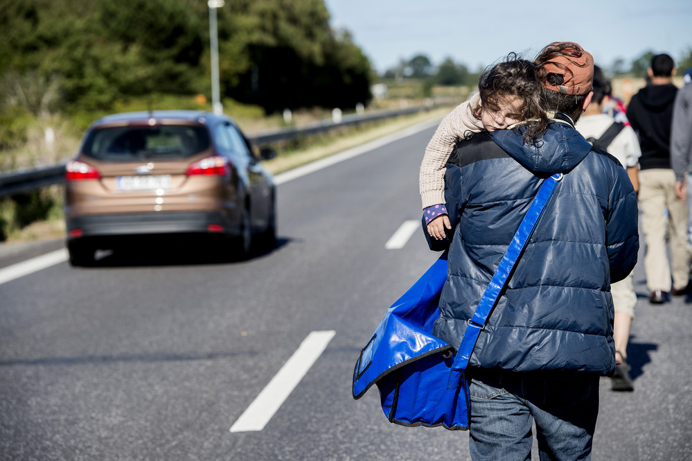 På motorvejen ved Rødby bærer en far sit sovende barn. Foto: Bax Lindhardt/Scanpix 