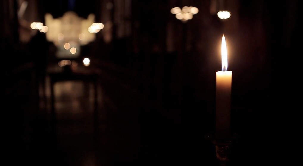 Enligt lys brænder i en mørk kirke