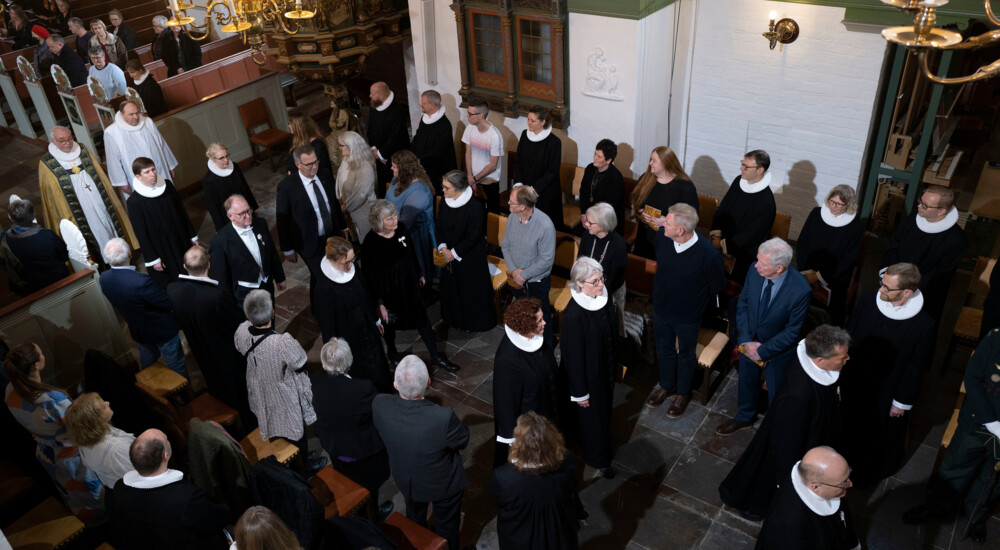 Stiftets provster, præster m.fl. går i midten af stående tilskuere