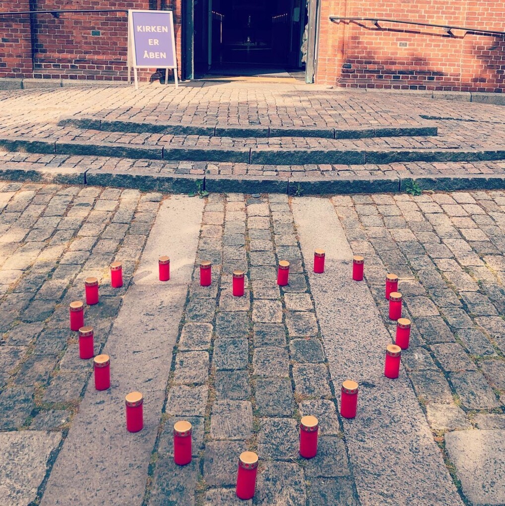 Tændte lys sat op som et hjerte foran Sundby kirke