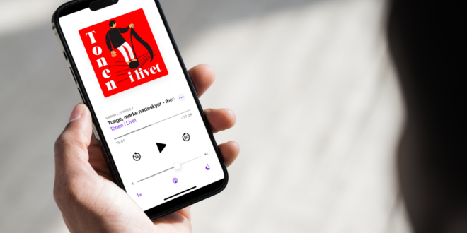 Person kigger på sin mobil, som afspiller podcasten Tonen i Livet fra folkekirken.dk