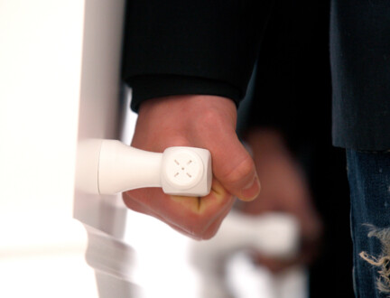 En hånd løfter i håndtaget på en hvid kiste.